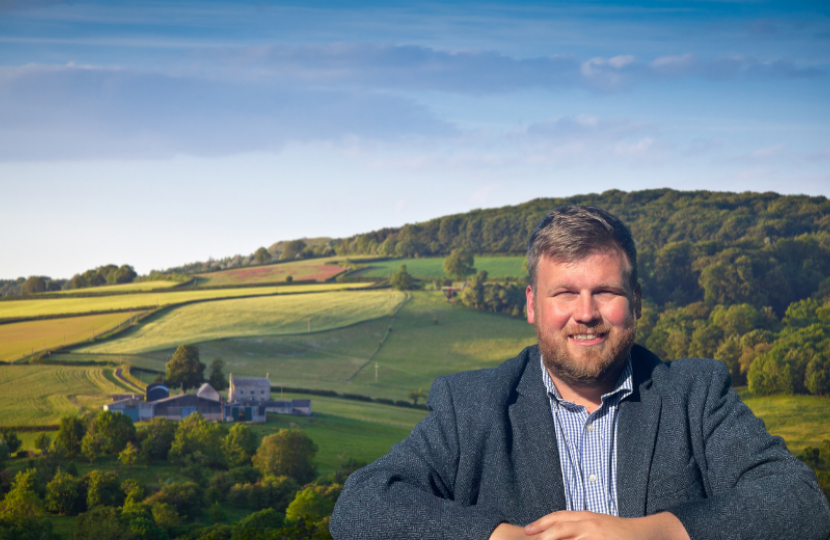 James standing in front of a background of fields