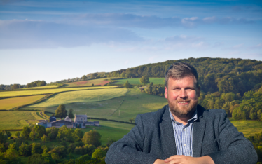 James standing in front of a background of fields